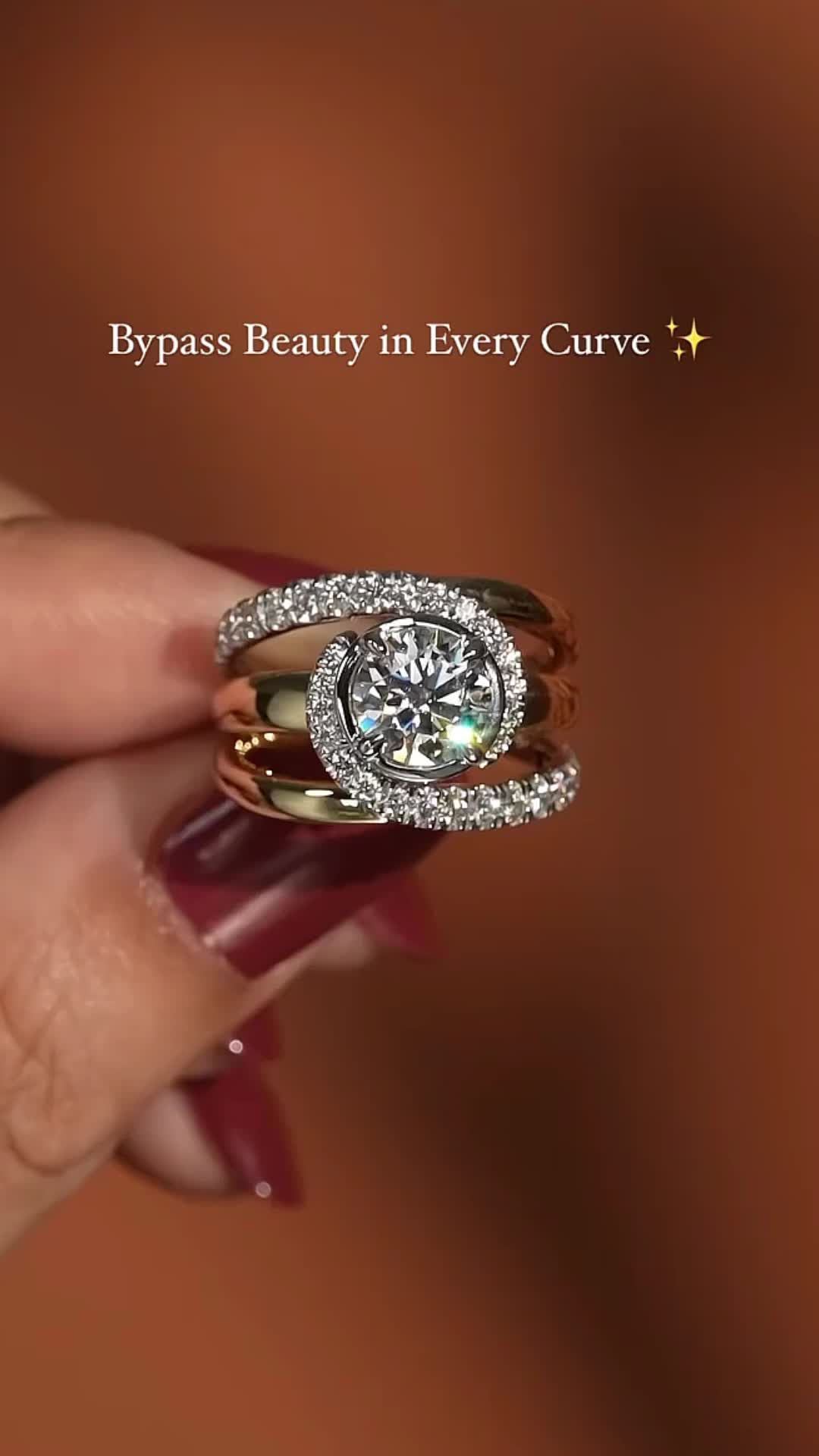 This may contain: a woman's hand holding a diamond ring with the words bypass beauty in every curve