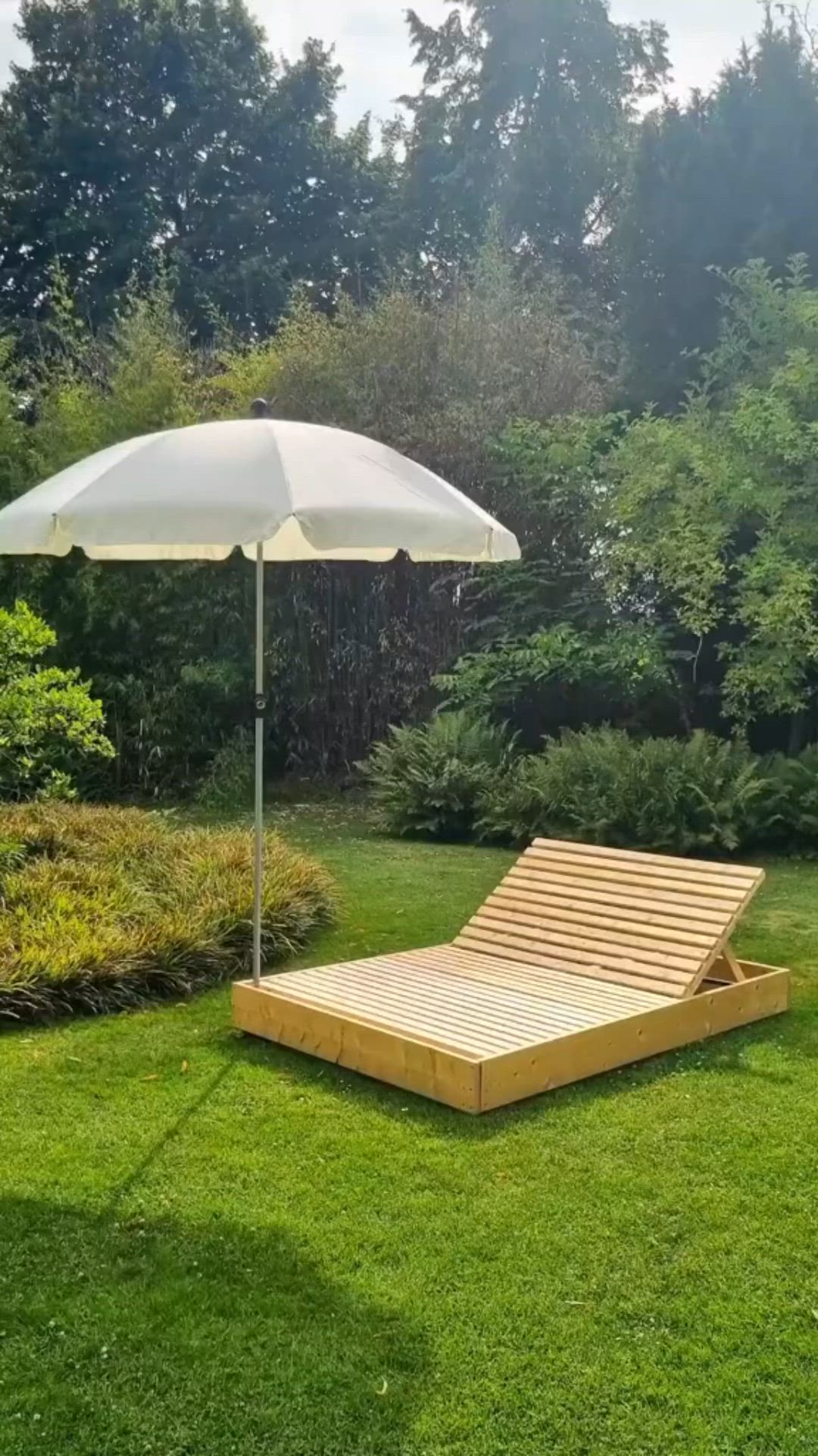 This may contain: an umbrella and chaise lounge in the grass