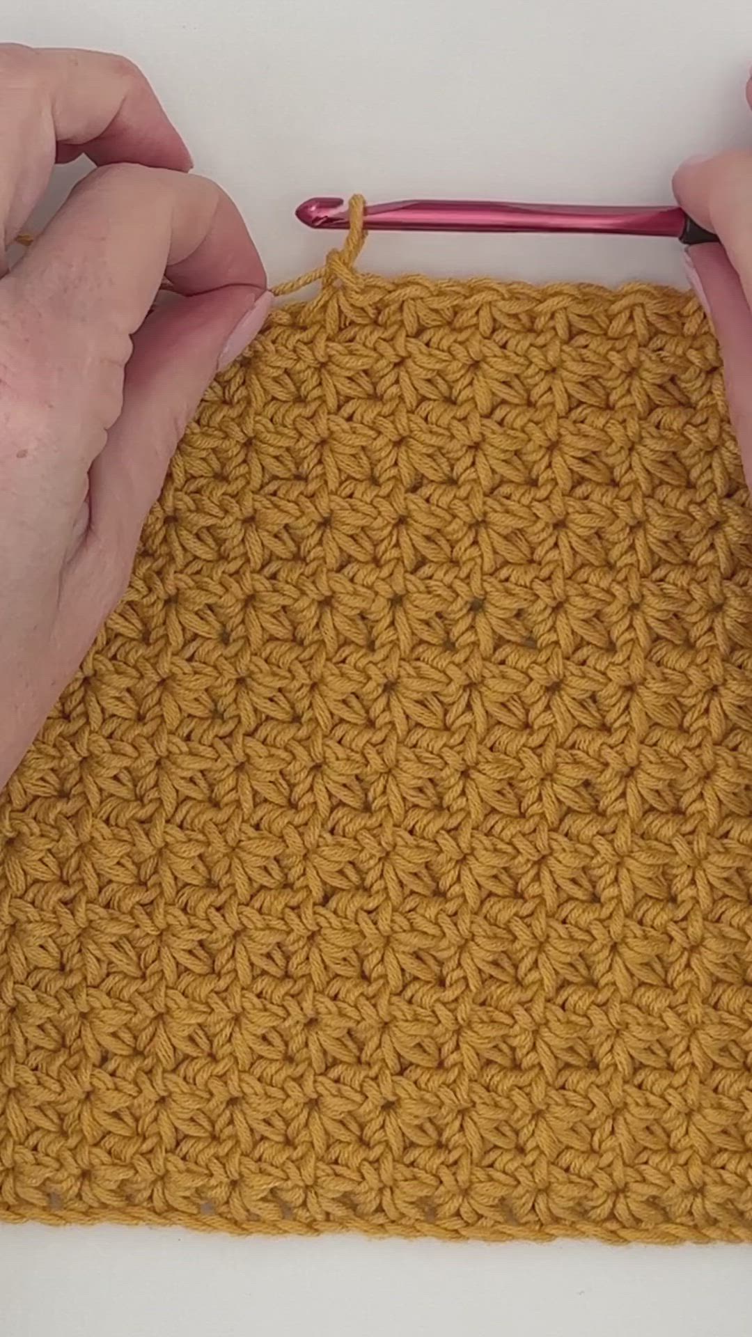 This contains: Crocheted blanket made in a golden yellow color. The stitch resembles flowers.