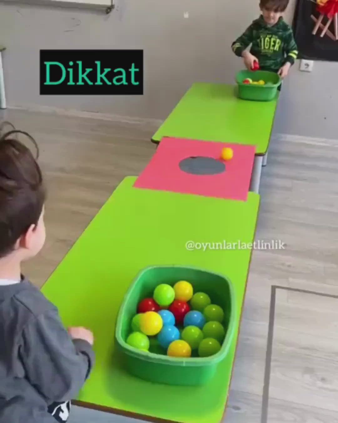 This may contain: two young boys playing with balls in a playroom