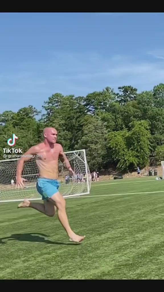 This may contain: a man running across a field with a frisbee