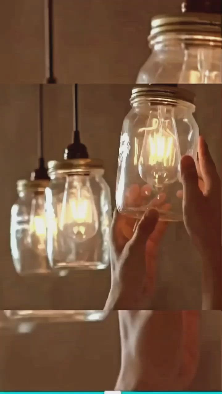 This may contain: three mason jars are hanging from the ceiling and one is filled with light bulb bulbs