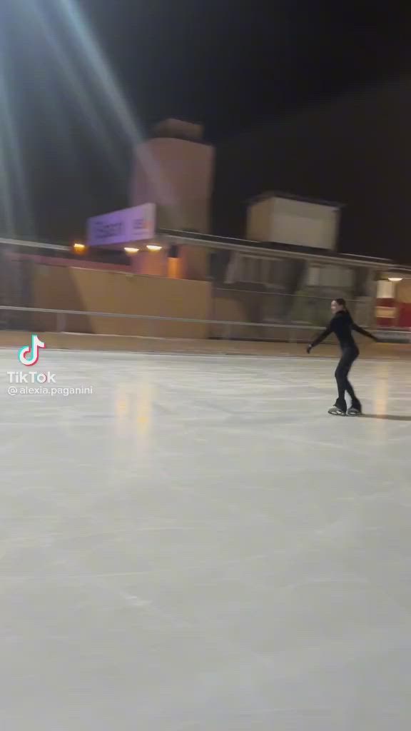 This may contain: a person skating on an ice rink at night