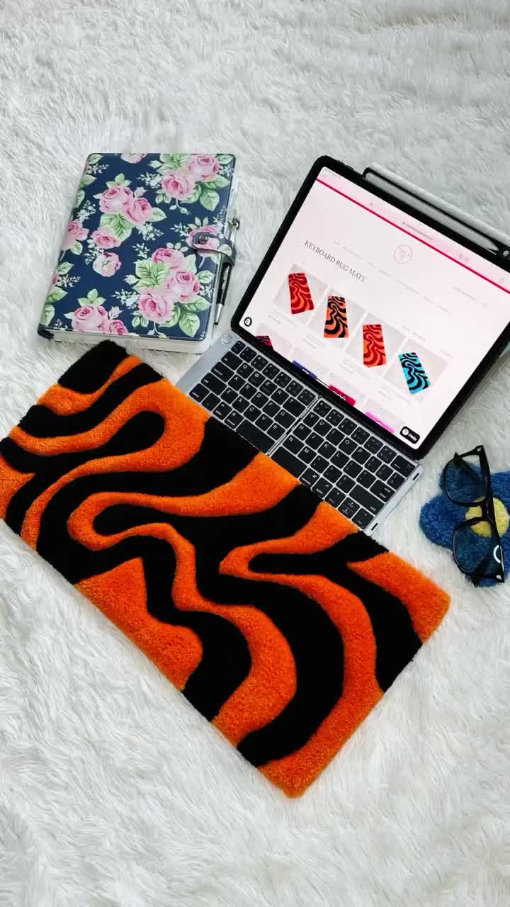 This may contain: an open laptop computer sitting on top of a white rug