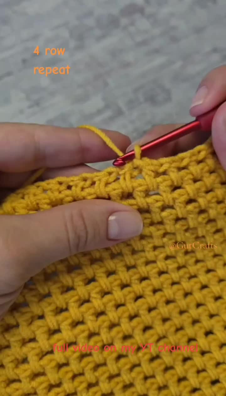 This may contain: someone crocheting the stitches on a yellow knitted blanket