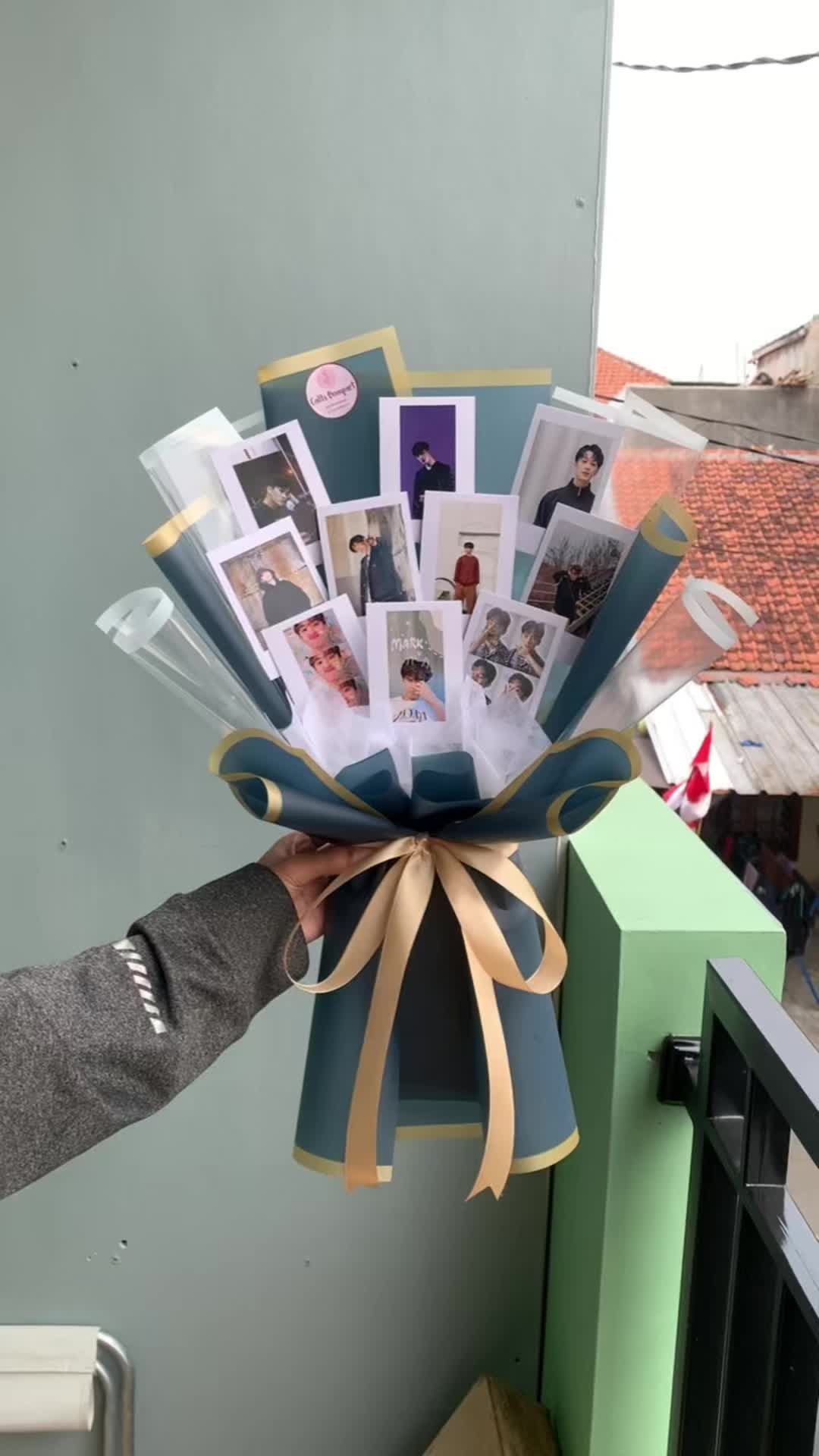 This may contain: a person holding up a bunch of photos in their hand with the ribbon tied around it