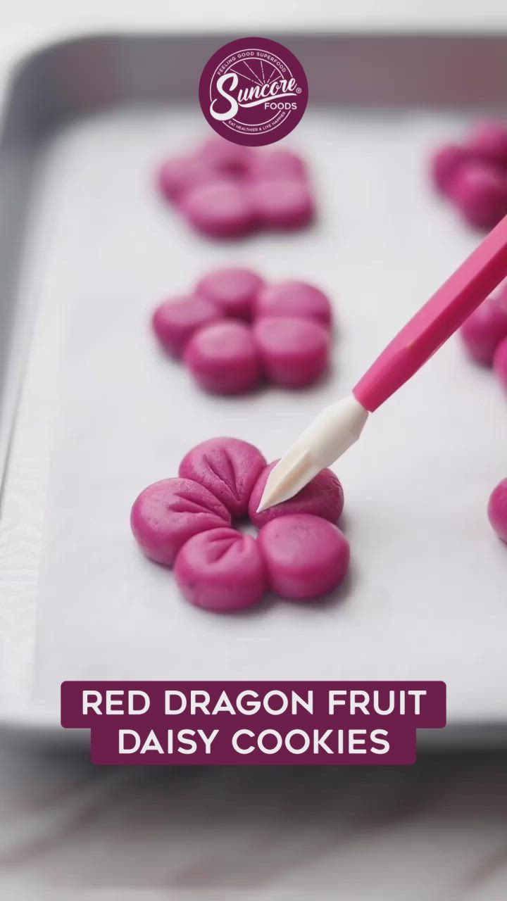 This may contain: red dragon fruit daisy cookies on a baking sheet with the words, red dragon fruit daisy cookies