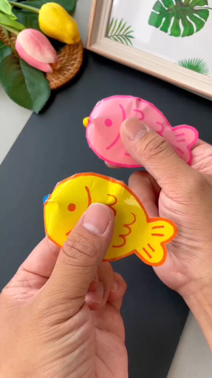 This may contain: a person is holding two small fish magnets