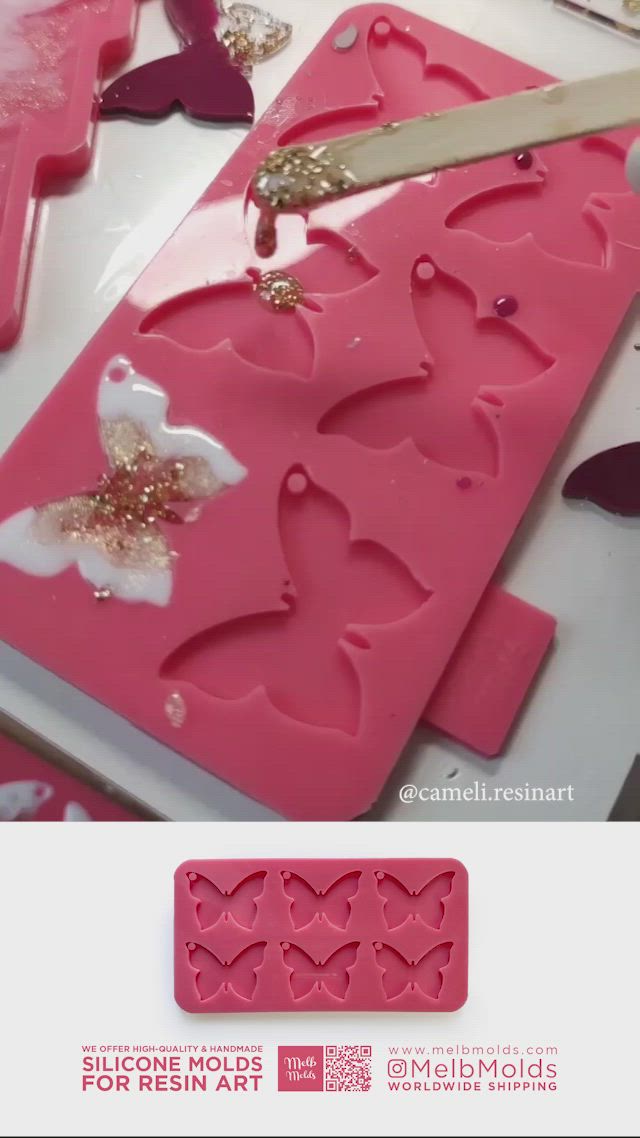 This may contain: someone cutting out hearts with scissors on top of a pink cake molding sheet that is shaped like a butterfly