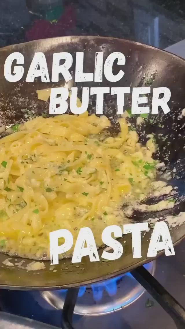 This may contain: a pan filled with food sitting on top of a stove next to the words garlic butter pasta