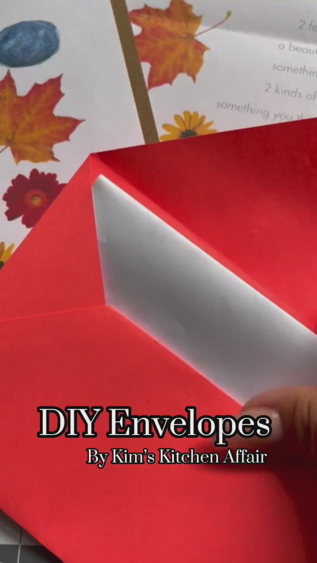 This may contain: three different colored envelopes on top of a cutting board with scissors and glue next to them