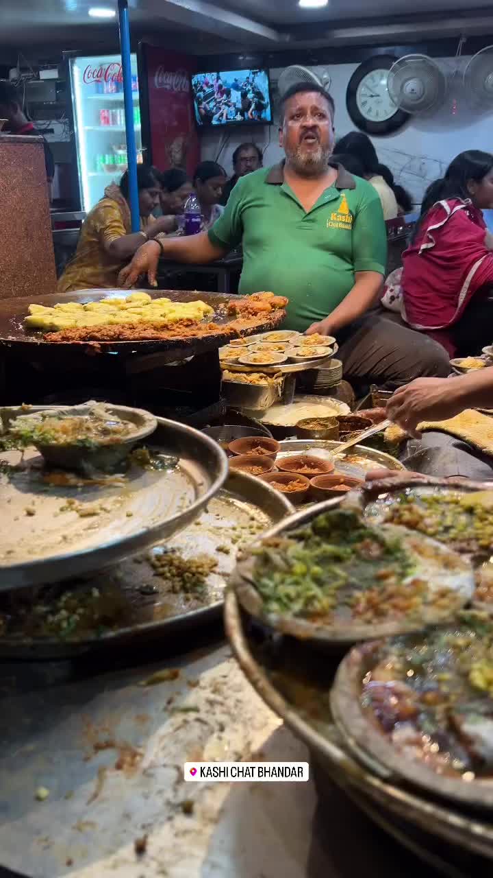 This may contain: a man sitting at a table filled with lots of plates and bowls full of food