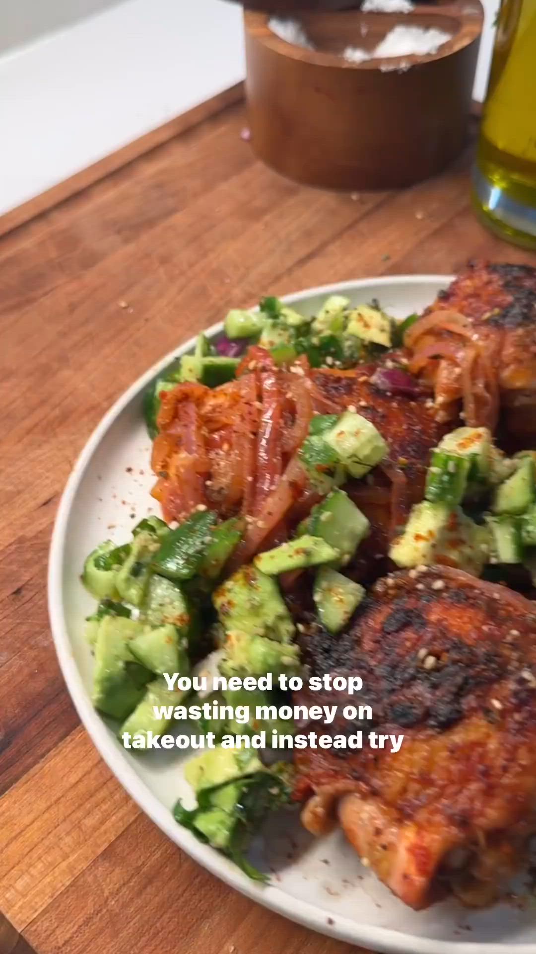 This may contain: a white plate topped with meat and veggies on top of a wooden table