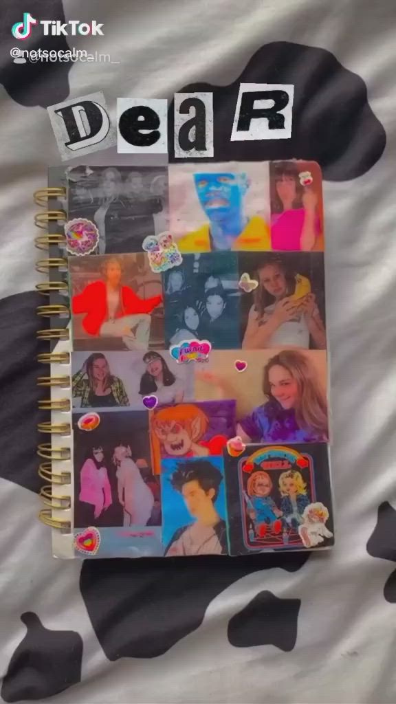 This may contain: a spiral notebook covered in stickers with the words dear written on it's cover