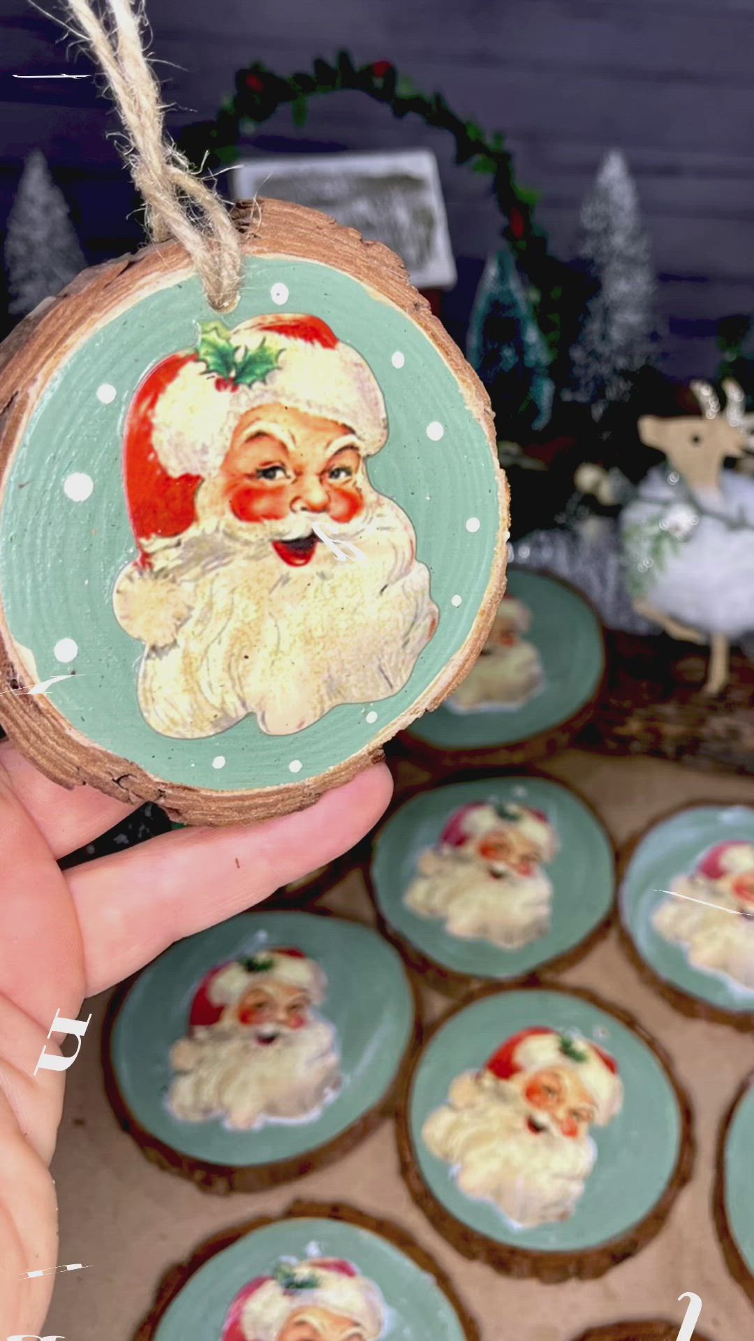 This may contain: a hand holding a christmas ornament with santa clause on it's face