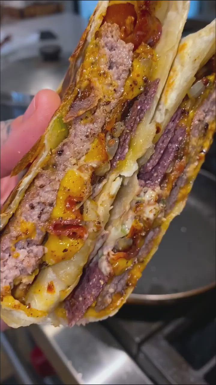 This may contain: the bacon cheeseburger crunch wrap recipe is ready to be eaten by someone else