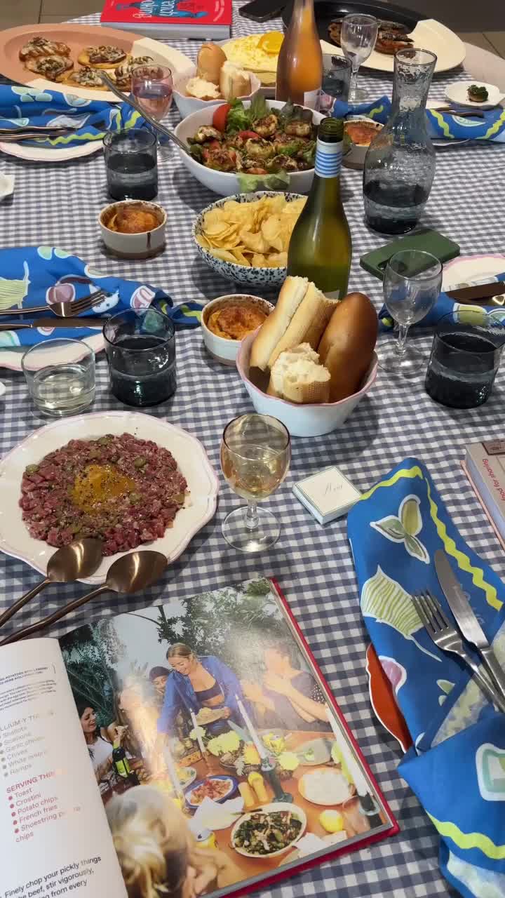 This may contain: a table full of food and drinks on top of a blue checkered table cloth