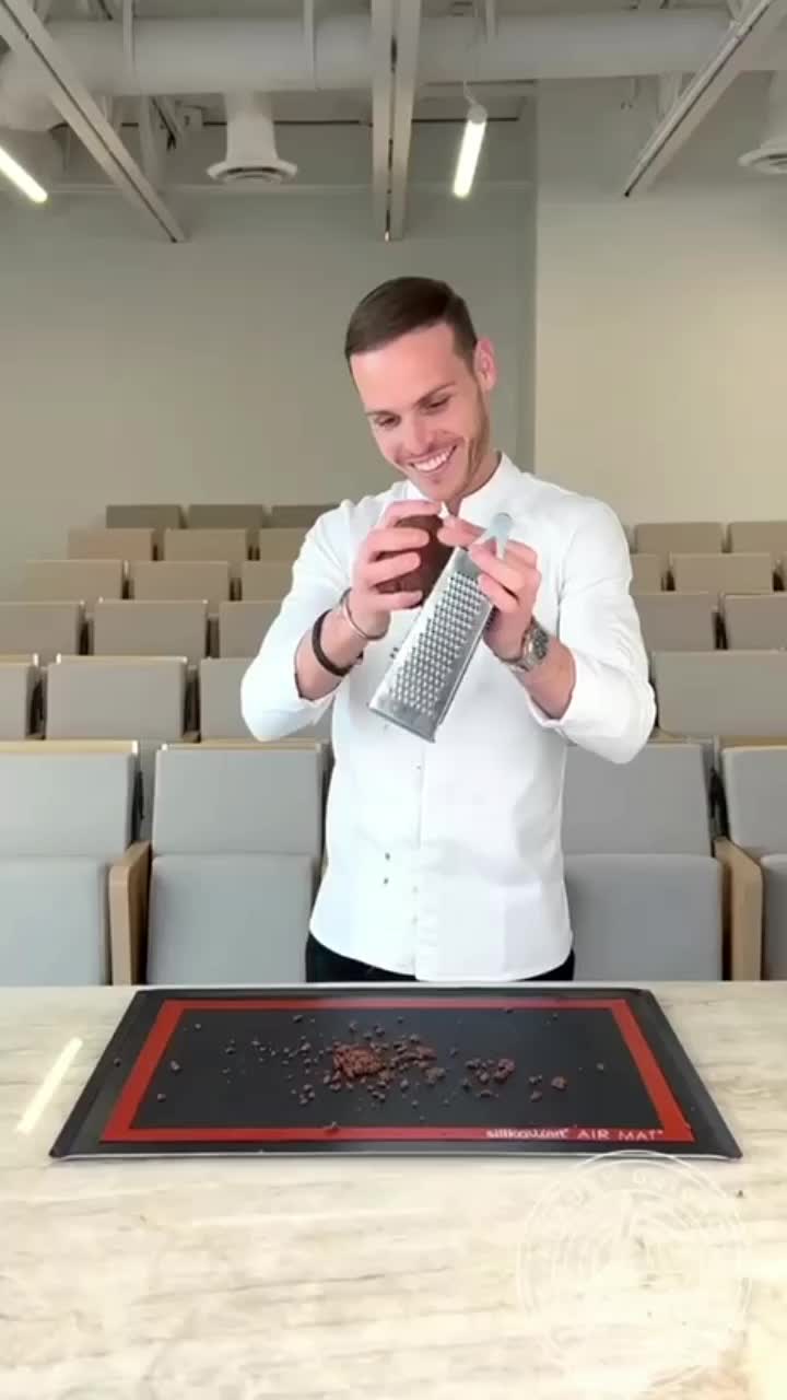 This may contain: a man standing in front of a table with food on it