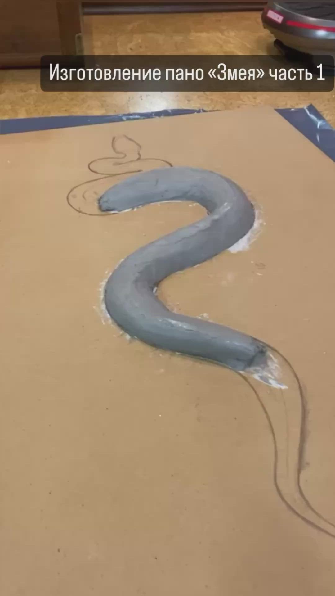 This may contain: an image of a snake that is in the middle of some sand and has it's tail curled up