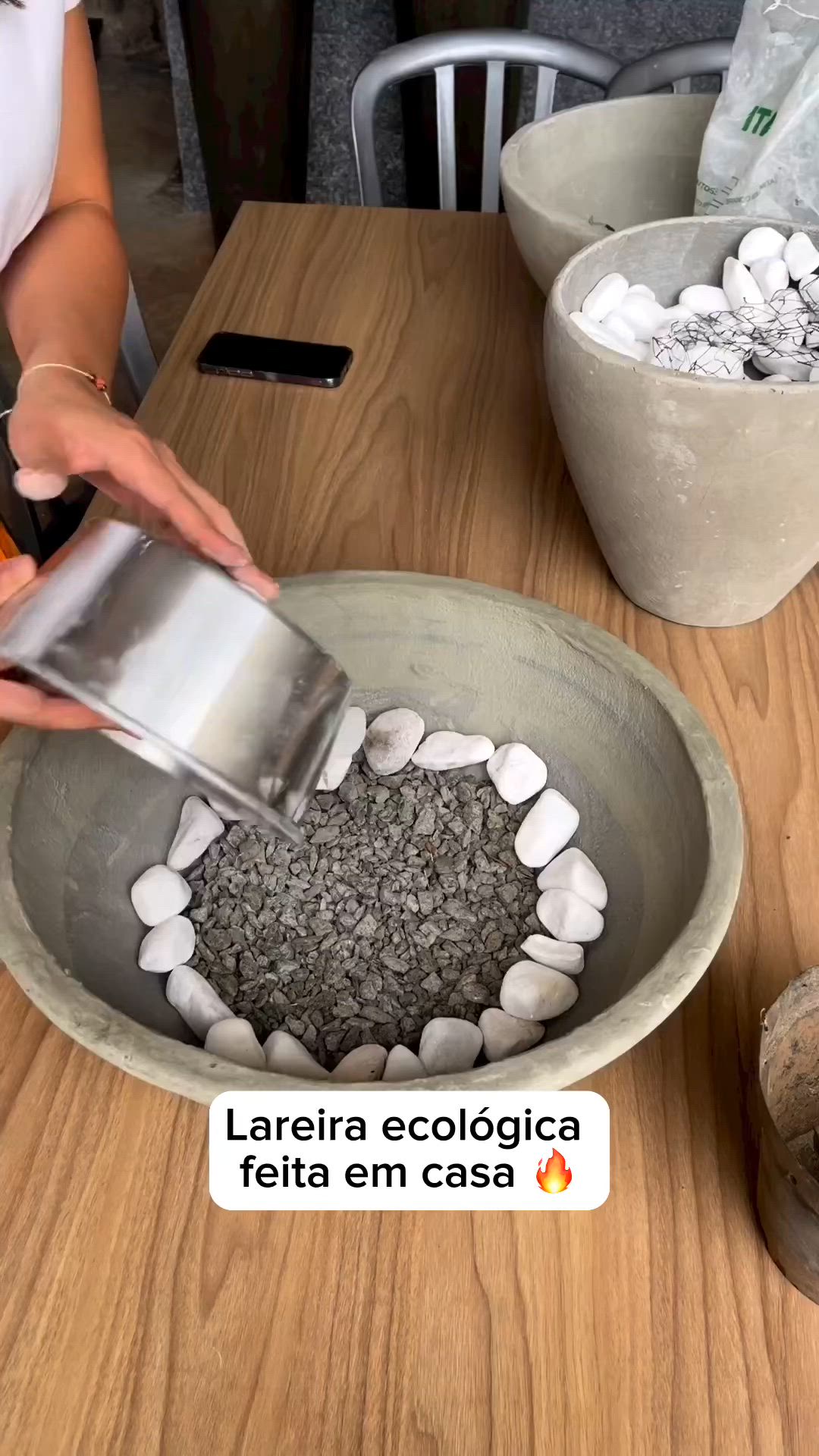 This may contain: a bowl filled with rocks sitting on top of a wooden table next to a phone