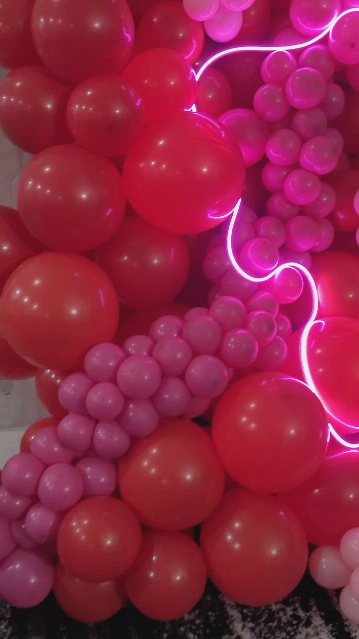 This may contain: a bunch of balloons that have been lit up with neon lights and some are laying on the ground