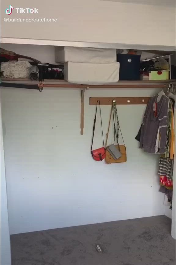 This may contain: the closet is filled with white shelves and hanging clothes on hooks, which are also made from plywood