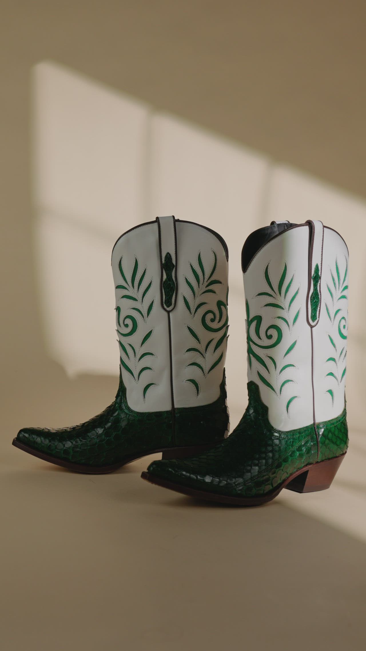 Western-style boots in emerald green python leather handmade with a modern style and stickies on the shaft are a unique and stylish footwear option. Python leather is a high-quality, durable material that is often used in luxury goods, and the emerald green color adds a bold and fashionable touch. The addition of stickies on the shaft gives the boots a textured and interesting look. These boots are likely to be of a high-end, luxury brand.