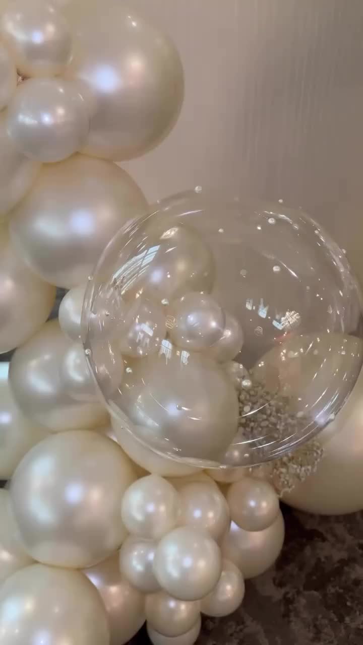 This may contain: some white balloons are in the shape of balls