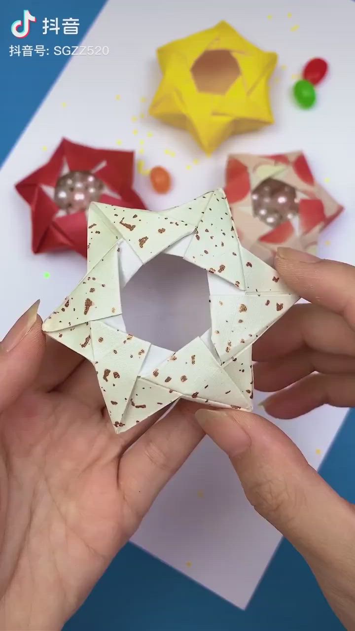 This may contain: someone is making an origami star out of paper