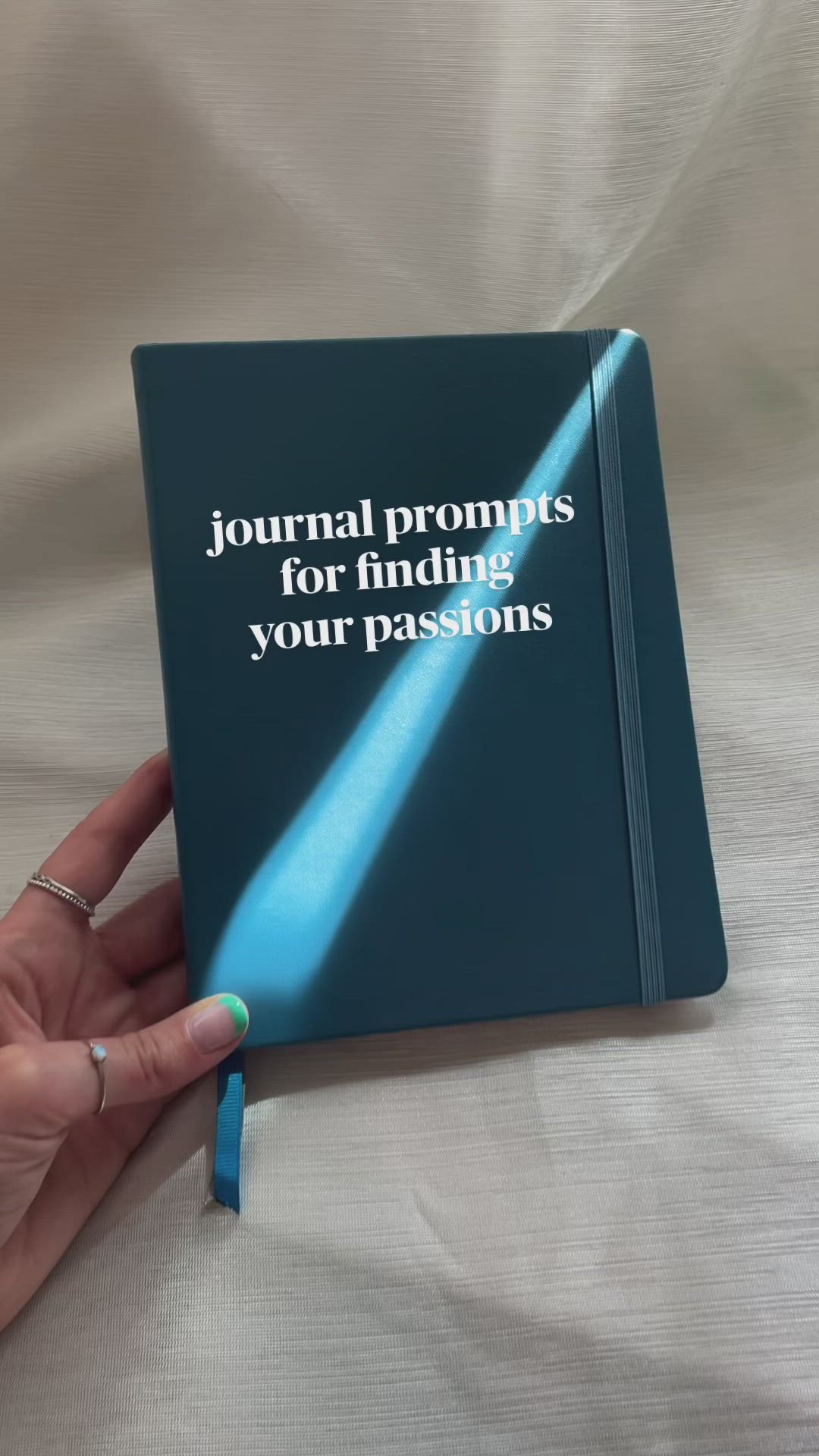 This may contain: a hand holding a blue book with the title journal propress for finding your passion