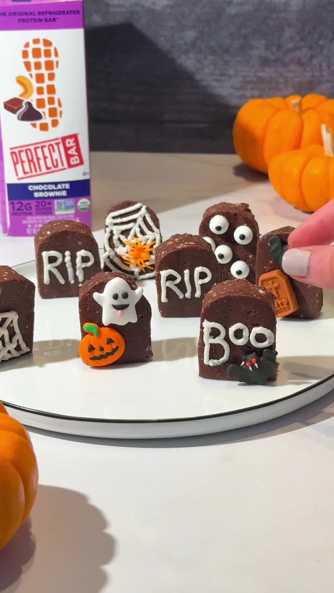 This may contain: halloween treats are arranged on a plate with candy in the shape of tombstones and ghost faces