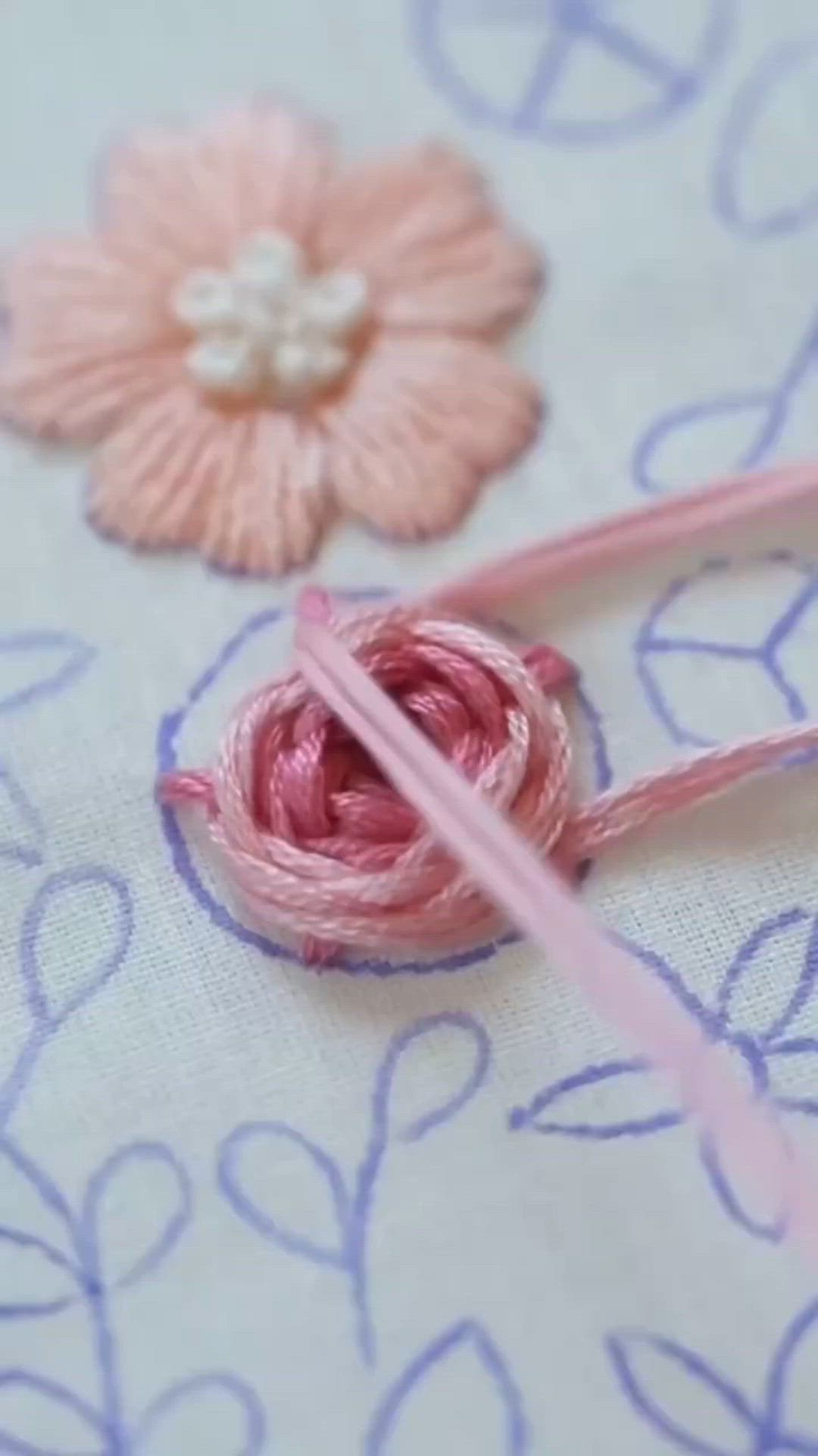 This may contain: a person is holding up a small embroidery kit with pink flowers on the front and back