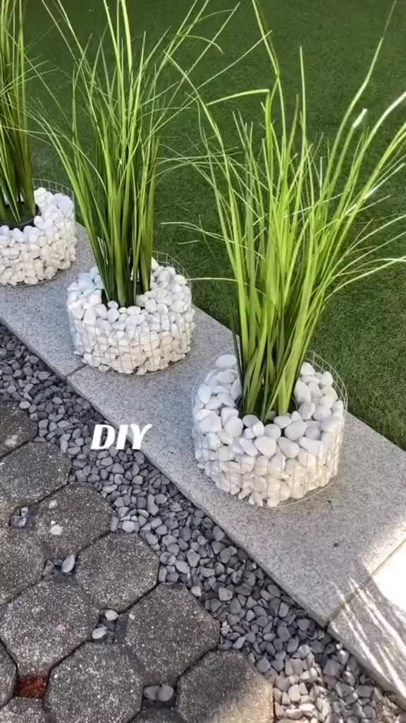 This may contain: three planters sitting on the side of some steps with rocks and grass in them