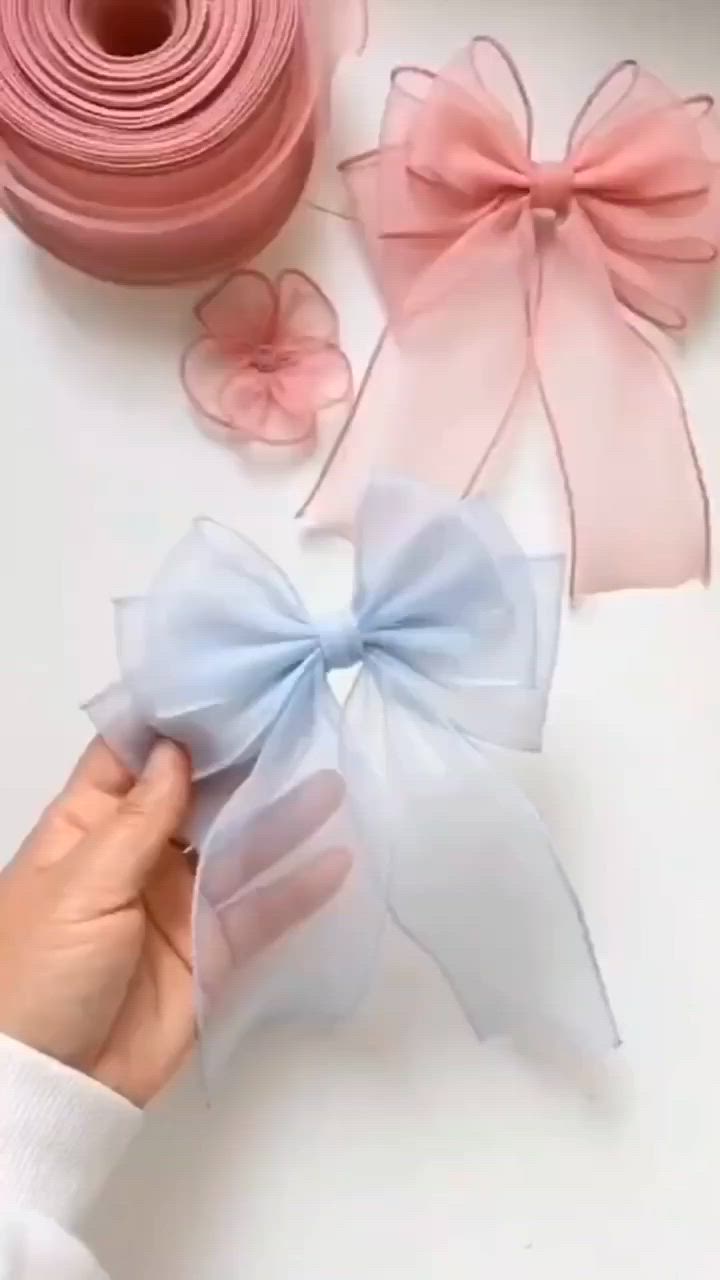 This may contain: someone is holding the ribbon on top of each other and it's being used to make bows