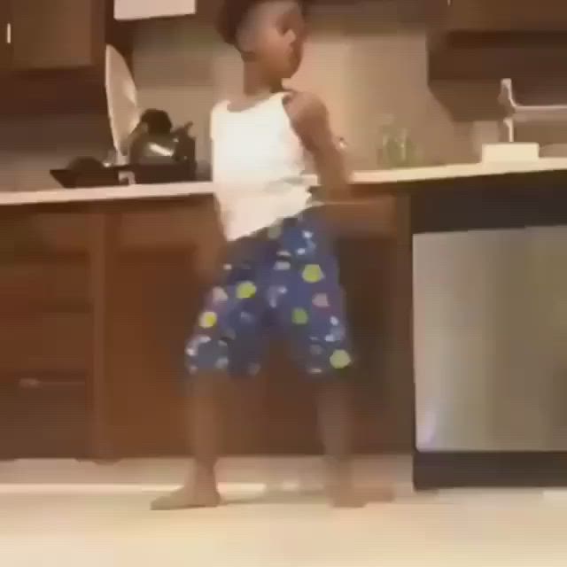 This may contain: a little boy standing in the middle of a kitchen