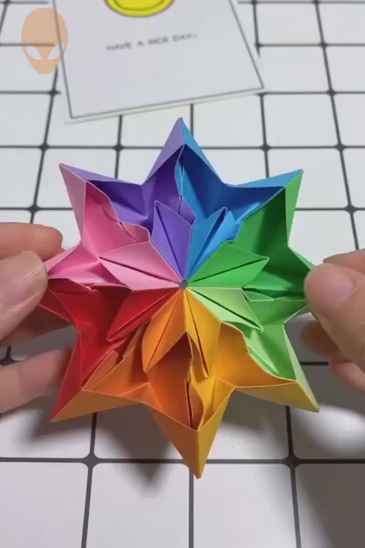 This may contain: someone is holding an origami star in their hands