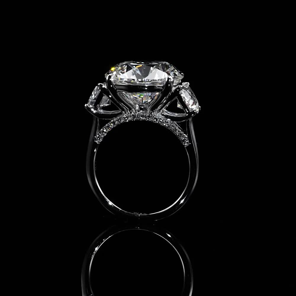 This may contain: a diamond ring with three stones on the top and bottom, set in black gold