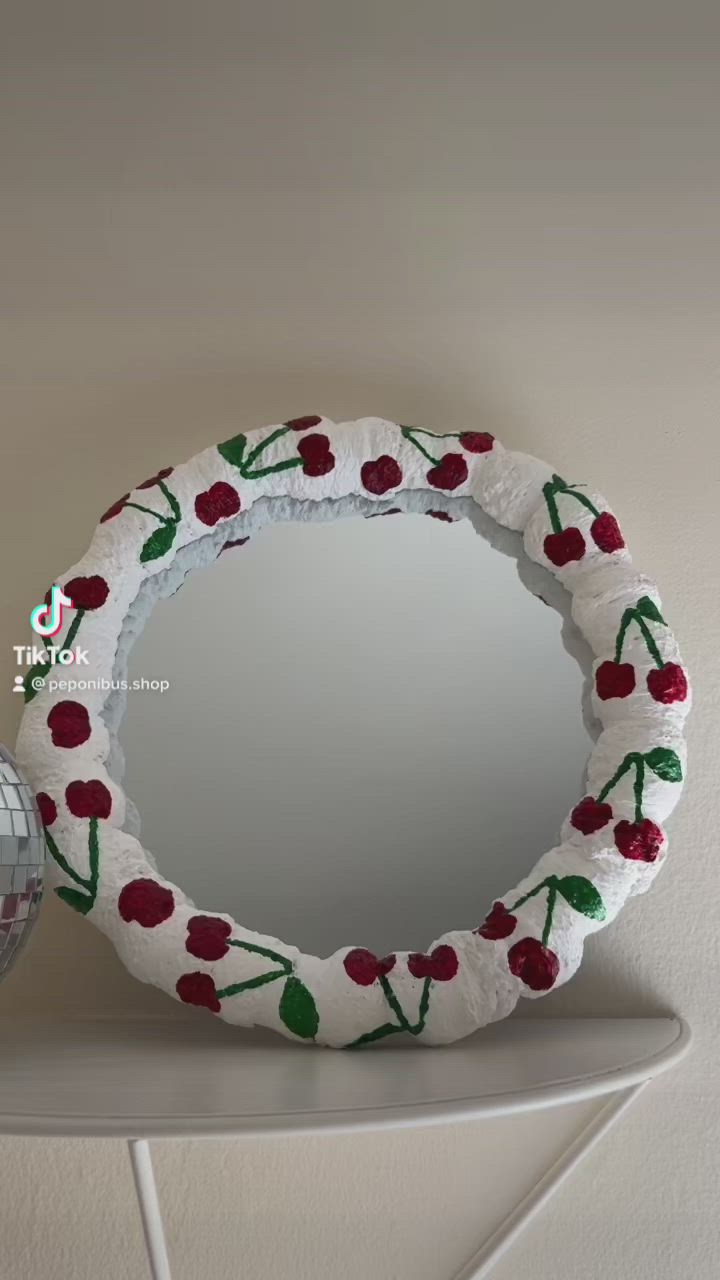 This may contain: a mirror with red flowers on it next to a disco ball