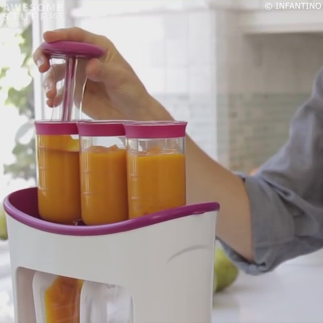 This may contain: a person holding a blender with orange juice in it and two cups on the side