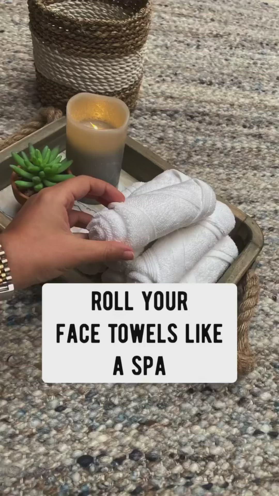 This may contain: a person is holding some towels on a tray with a candle and succulents