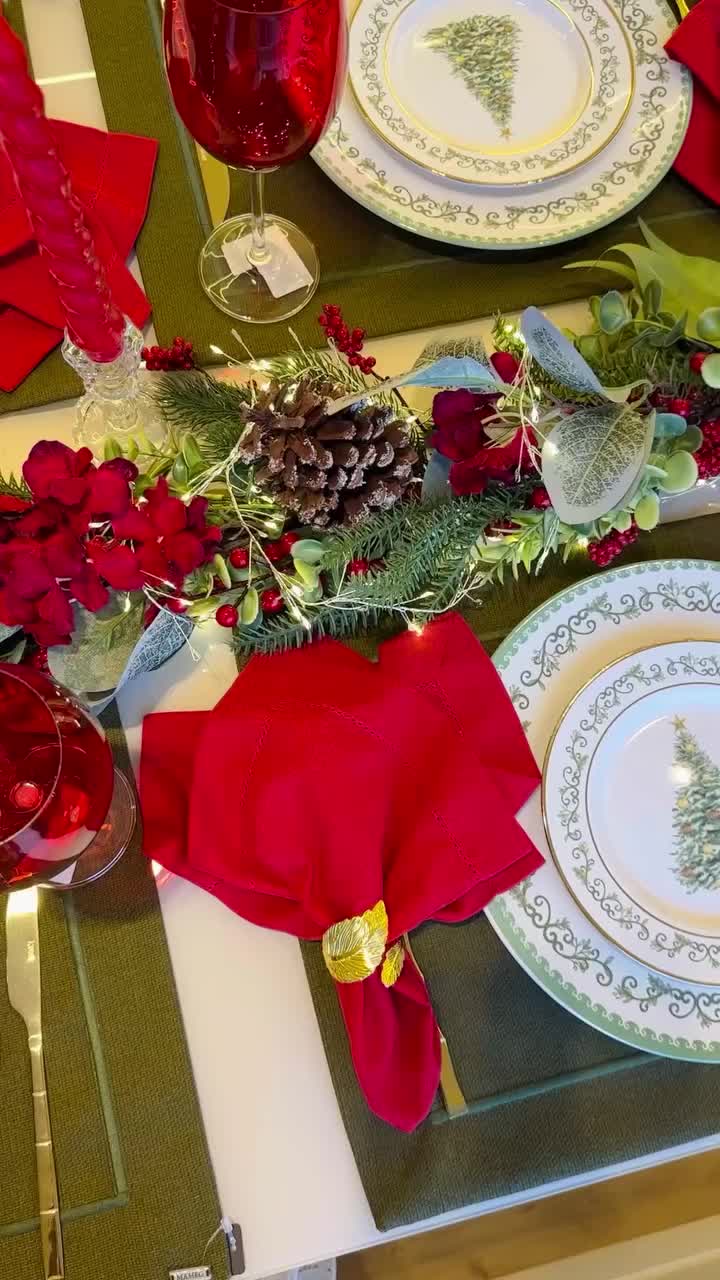 This may contain: the table is set for christmas dinner with plates and napkins