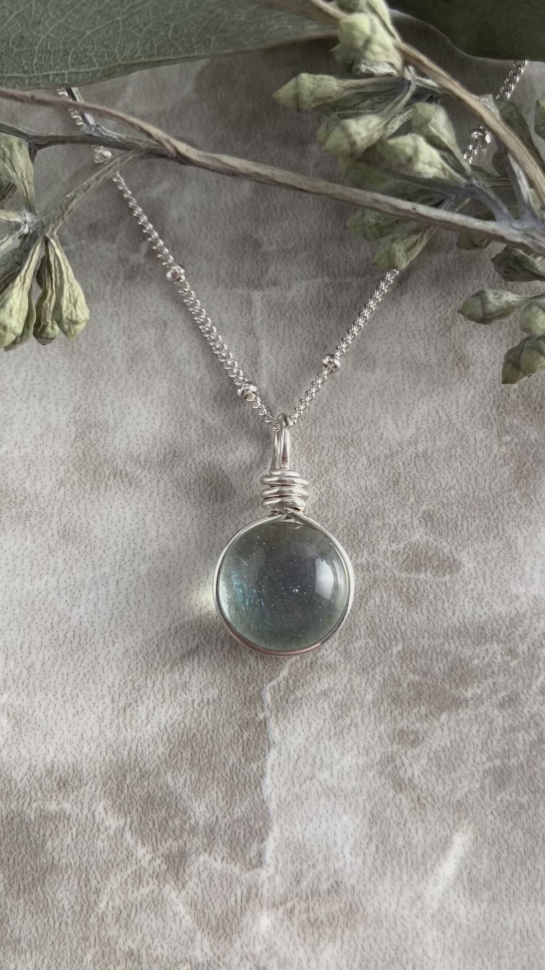 This contains: Dainty Light Green Art Glass Pendant on a Sterling Silver Satellite Chain.