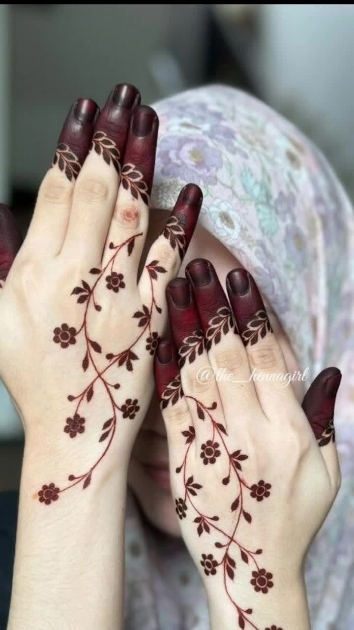 This may contain: two women with their hands painted with hendi designs