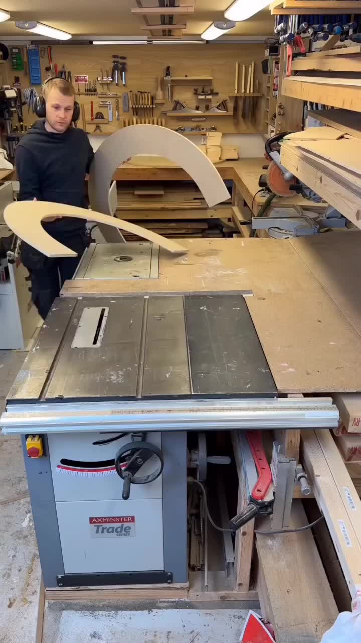 This may contain: a man standing in front of a table sawing