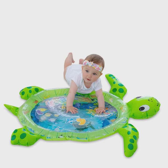 This may contain: a baby crawling on top of an inflatable turtle