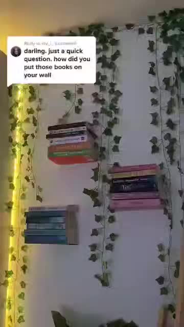 This may contain: a stack of books sitting on top of a metal table next to a white wall