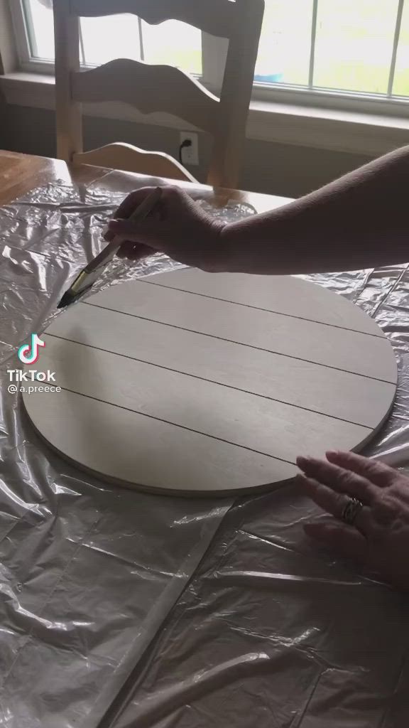 This may contain: a person cutting up a board on top of a plastic tablecloth covered table cloth