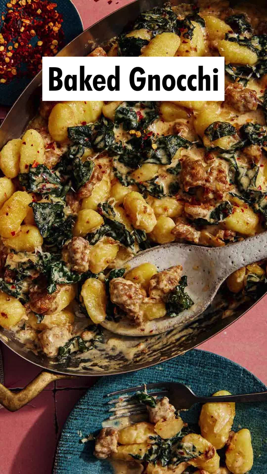 This may contain: baked gnocchini with spinach and sausage in a skillet on a table