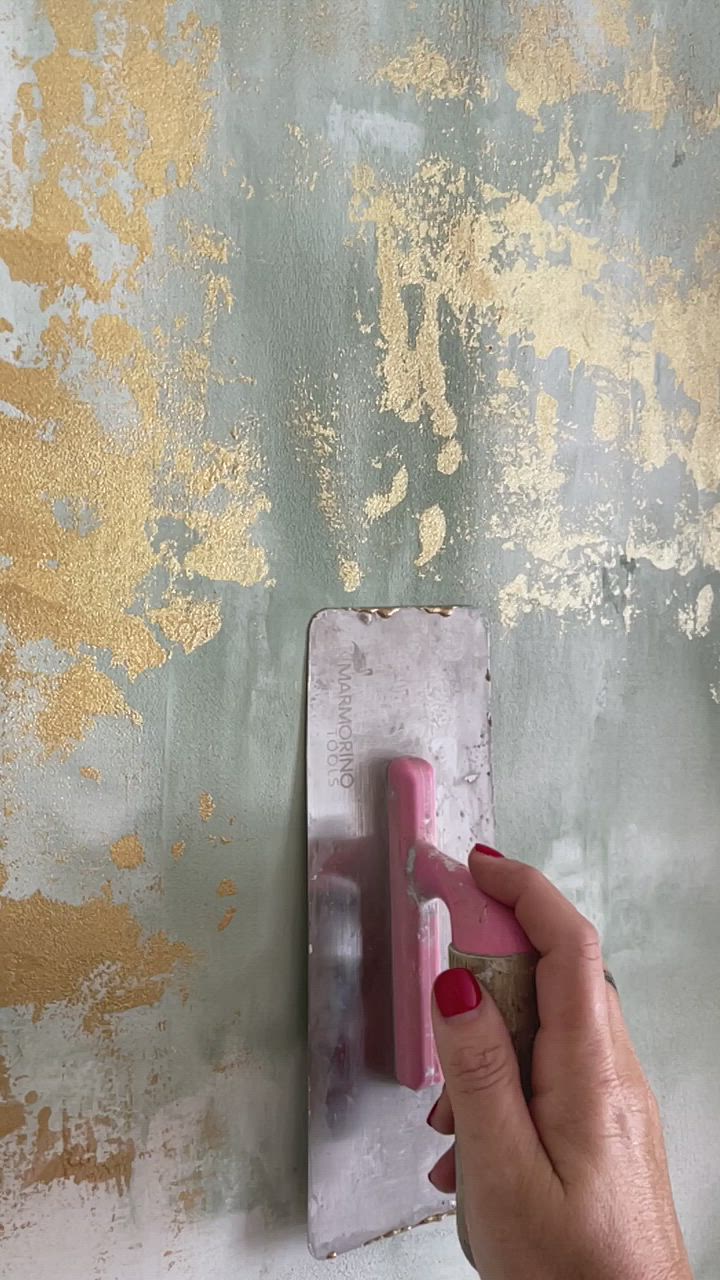 This may contain: a person is painting a wall with yellow and gray paint on it, using a brush