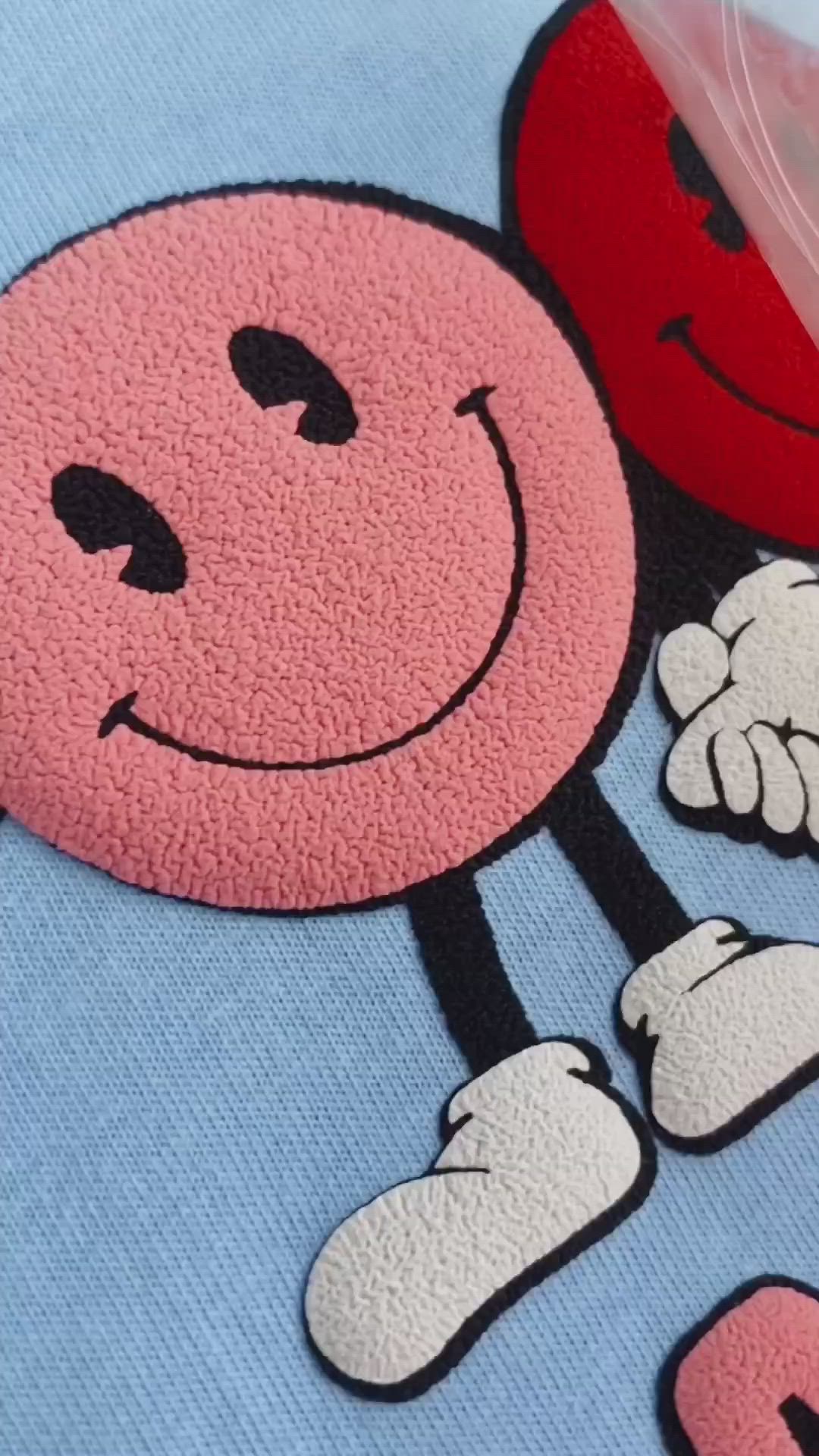 This may contain: a blue shirt with red letters and mickey mouse faces on it's chest is shown